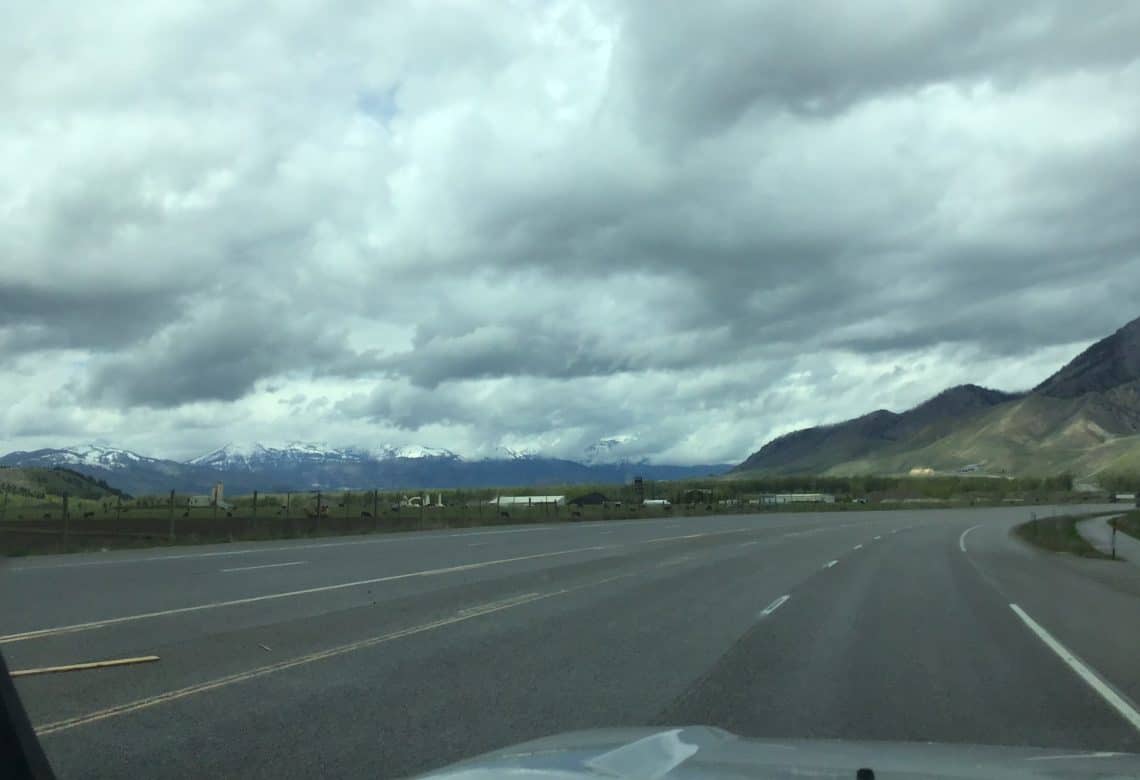 Road curving out of sight with mountains in the background.