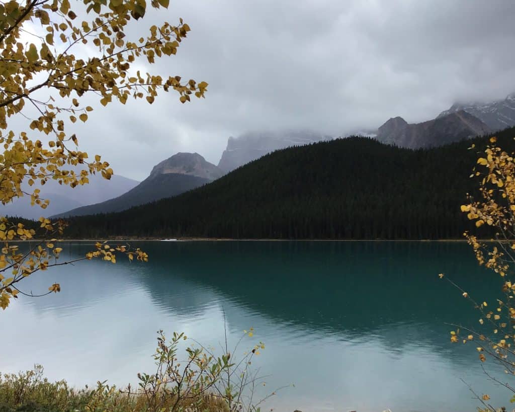 lake with extremely cool backdrop of mountains shrouded in fog.